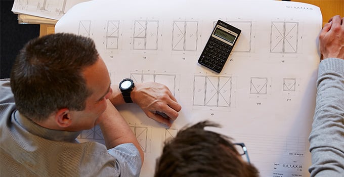 VELFAC employee and customer calculating costs and looking at drawings of new windows 