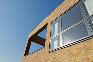 Dark colors make the window frame blend with the actual pane and create a smooth transition and calm facade